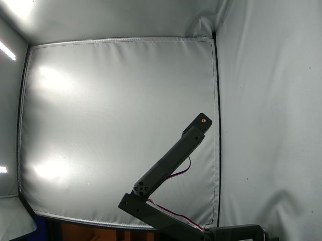 The robotic arm inside its illuminated recording enclosure